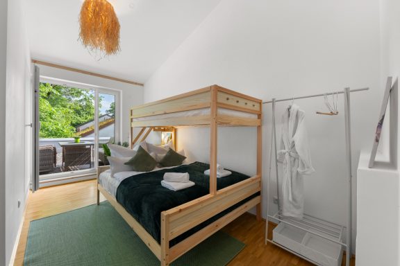 Helle, minimalistische Wohnung mit Etagenbett und Zugang zur Terrasse.